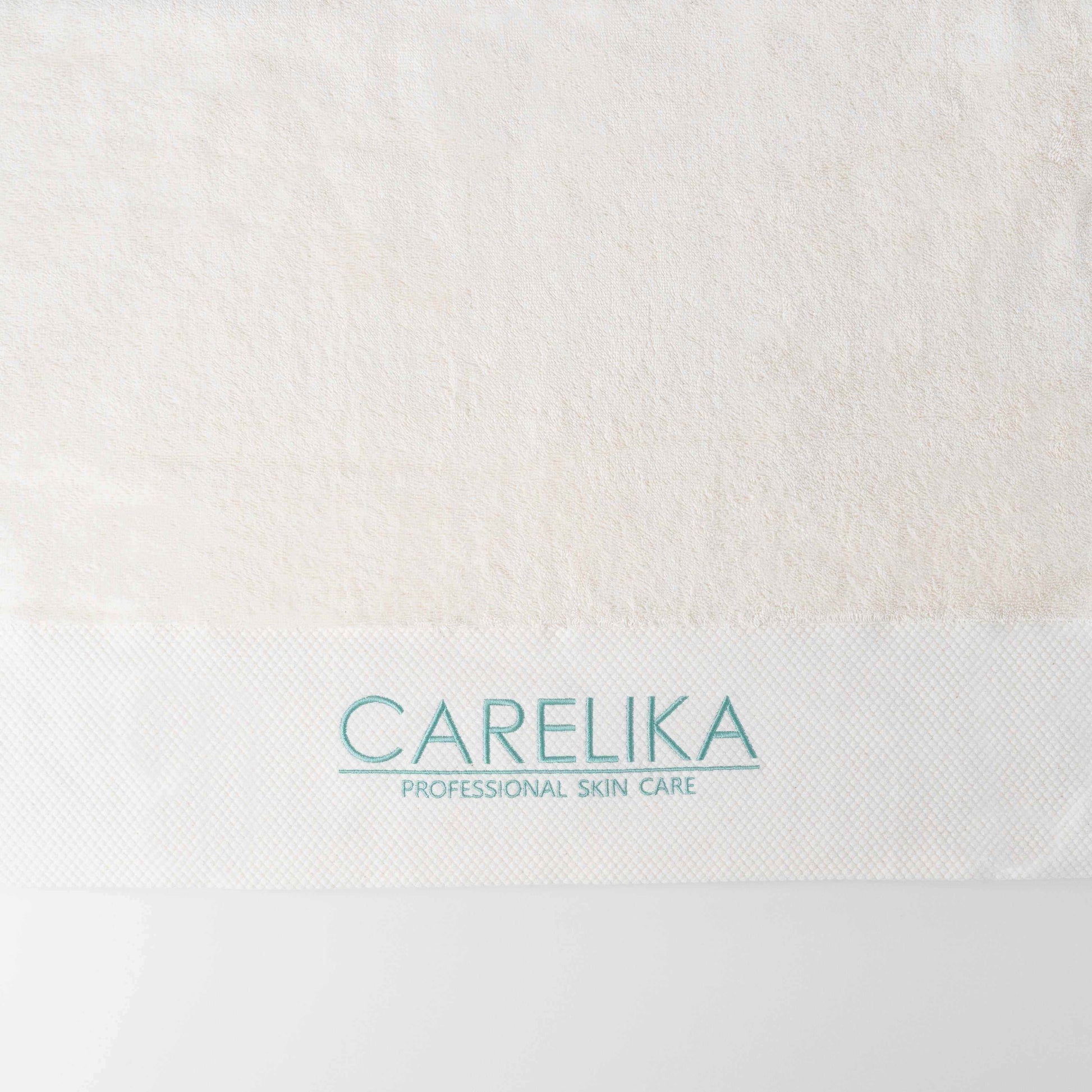 Carelika Bath Towel in classic white with logo, showcasing softness and luxury for optimal drying experience.