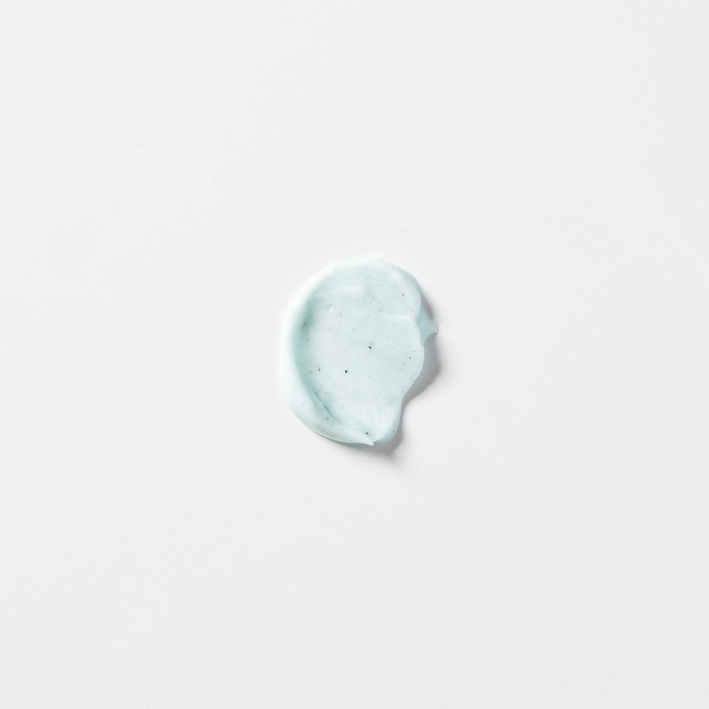 Light blue creamy texture of Carelika energizing face scrub on a white background.