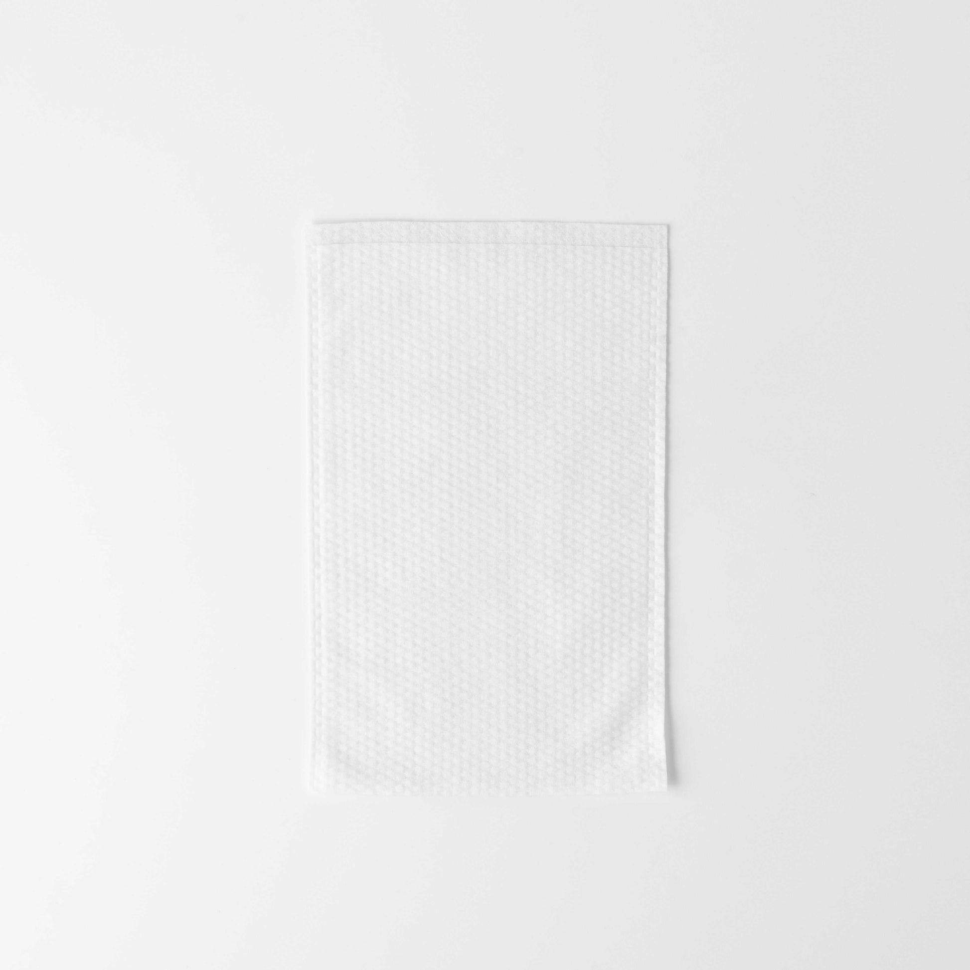 White disposable soft washing mitten for gentle facial cleansing and comfort in cosmetologic procedures.