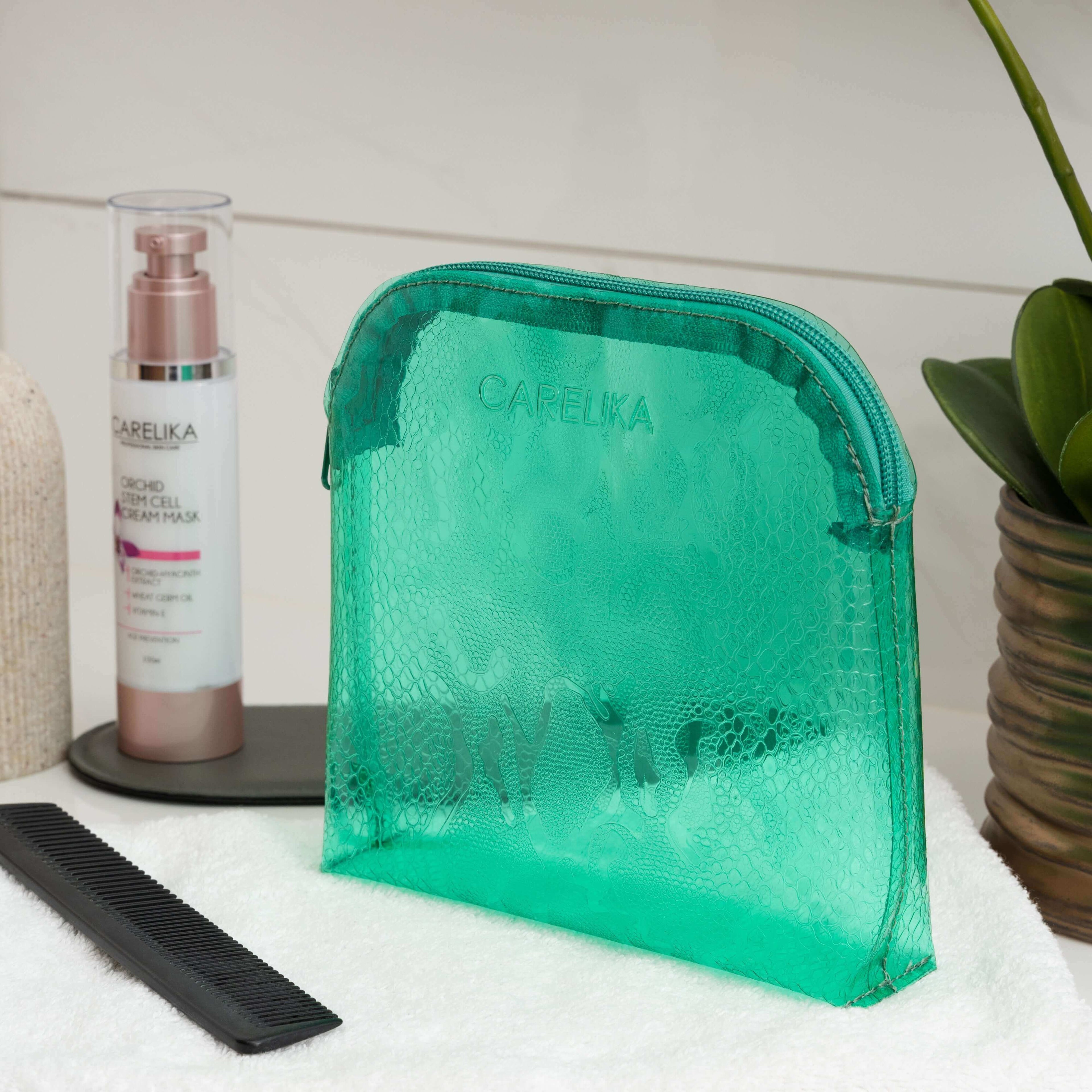 Carelika green cosmetic bag showcasing a sleek design alongside beauty products and a comb on a vanity countertop.